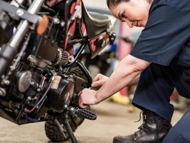 Foto mujer reparando moto